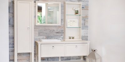 Ein geschmackvoll eingerichteter Raum mit einem weißen Schrank, einem Spiegel und einer schönen Dekoration aus Blumen und Kerzen.